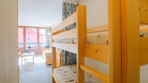 A dormitory room with bunk beds, a desk, and a chair. - Grandes Platières II by Interhome (Tignes)