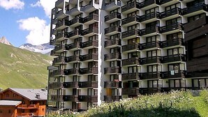 A multi-story hotel with balconies, set against a mountainous backdrop. - Grandes Platières II by Interhome (Tignes)