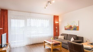 A modern living room with a sofa, coffee table, and dining area. - Wiesenblick (A706) by Interhome (Lahnstein (Koblenz))
