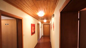 A hallway with wooden ceiling and checkered floor tiles, leading to a door marked "WC". - Jägerhof by Interhome (Schwaz)