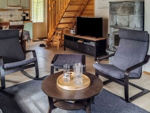Uma sala de estar moderna com dois poltronas, uma mesa de centro e uma televisão.