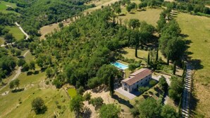 An aerial view of a property with a swimming pool, a large building, and surrounding greenery. - La Badia by Interhome (Vicchio)