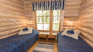 A cabin room with two beds, a window, and a small table. - Koivuranta by Interhome (Jämijärvi)