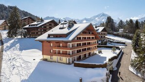 A multi-story lodge with a ski slope in the background. - Hyacinthe 11 by Interhome (Villars)