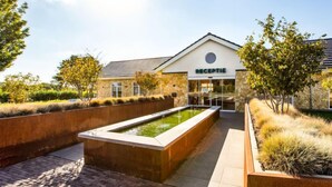 A reception area with a stone facade, a water feature, and a paved walkway. - Green Resort Mooi Bemelen by Interhome (Bemelen)