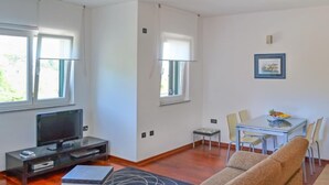 Una sala de estar moderna con una televisión de pantalla plana, una mesita y un sofá.