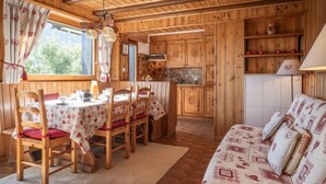 A cozy cabin interior with a dining area, kitchen, and a sofa. - Apartment Mélèze by Interhome (Ovronnaz)