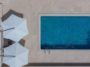 Ein Schwimmbecken mit klar blauem Wasser, umgeben von einer gefliesten Wand.