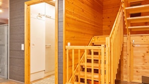 A wooden interior with a staircase and a door leading to a bathroom.