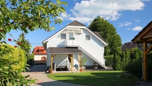 Et toetagers hus med en overdækket veranda og en trappe op til øvre etage.