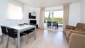 Un comedor moderno con una mesa de vidrio, sillas negras y un sofá.