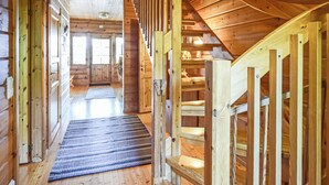A wooden interior with a staircase, wooden walls, and a patterned rug. - Linnunlaulu by Interhome (Lapinlahti)