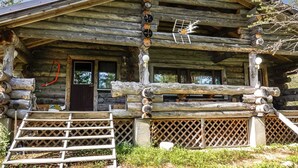 Un rustico chalet di legno con portico, una porta e una finestra.