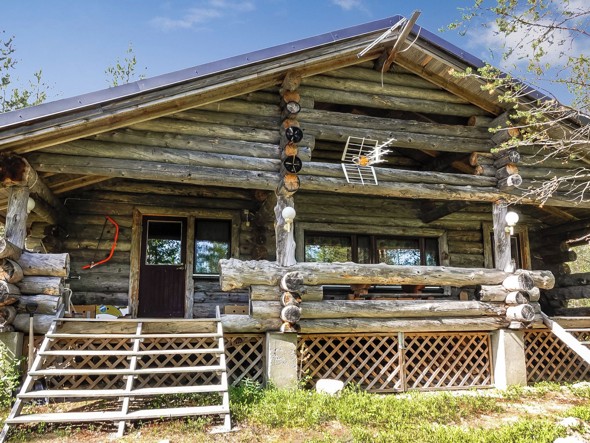 A log cabin with a front porch, a door, and a small window.