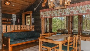 Un interno rustico con una panca di legno, un tavolo da pranzo e sedie.
