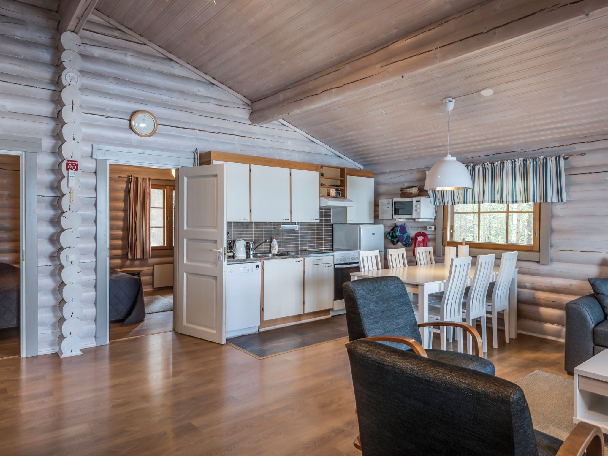 L’intérieur d’une cabane en rondins comprend une cuisine, un coin repas et un espace de vie.