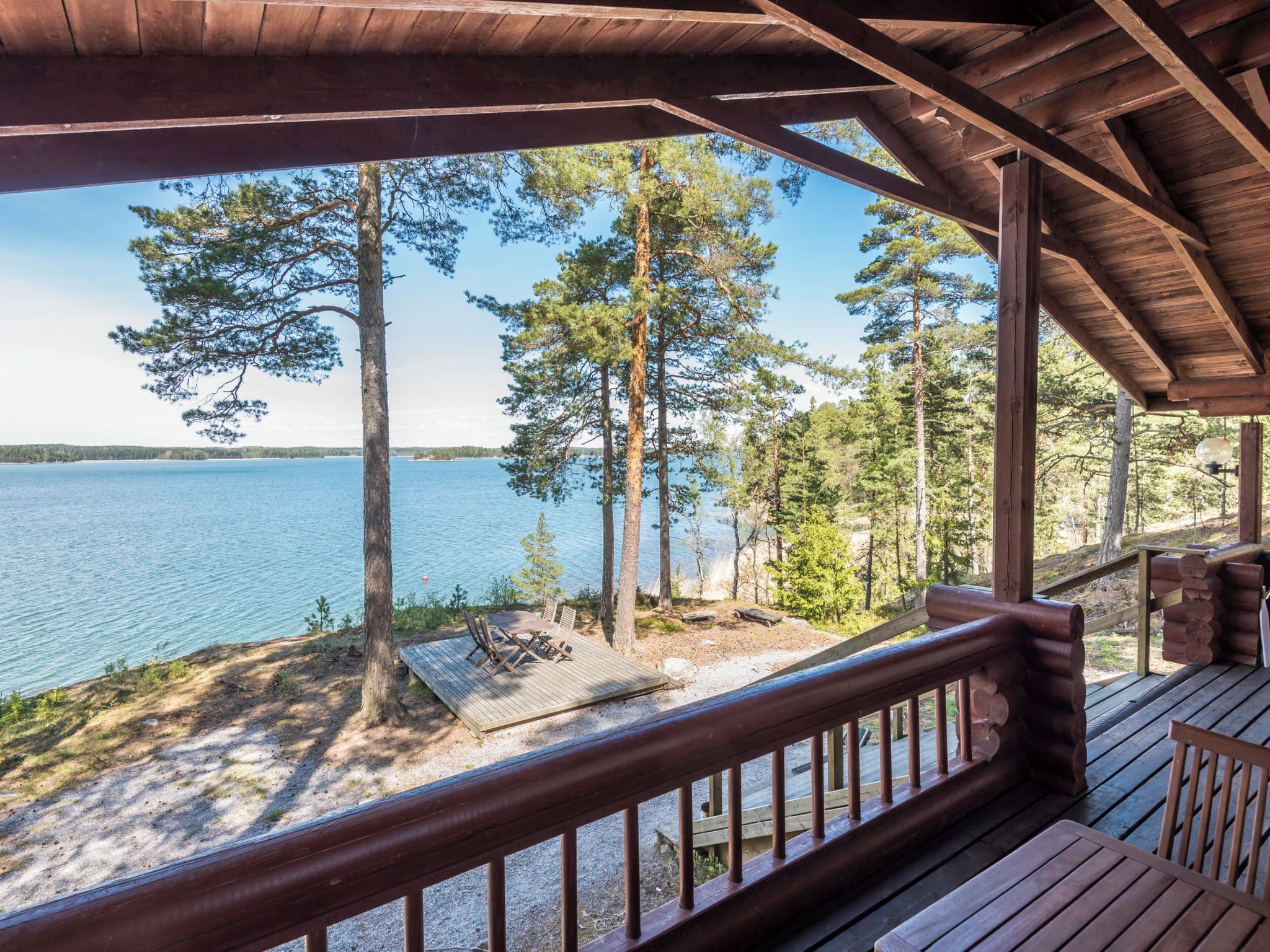 A wooden deck with a view of a lake and trees.
