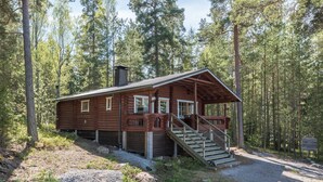 A wooden cabin with a porch and stairs, surrounded by a forest. - Merimetso by Interhome (Sauvo)