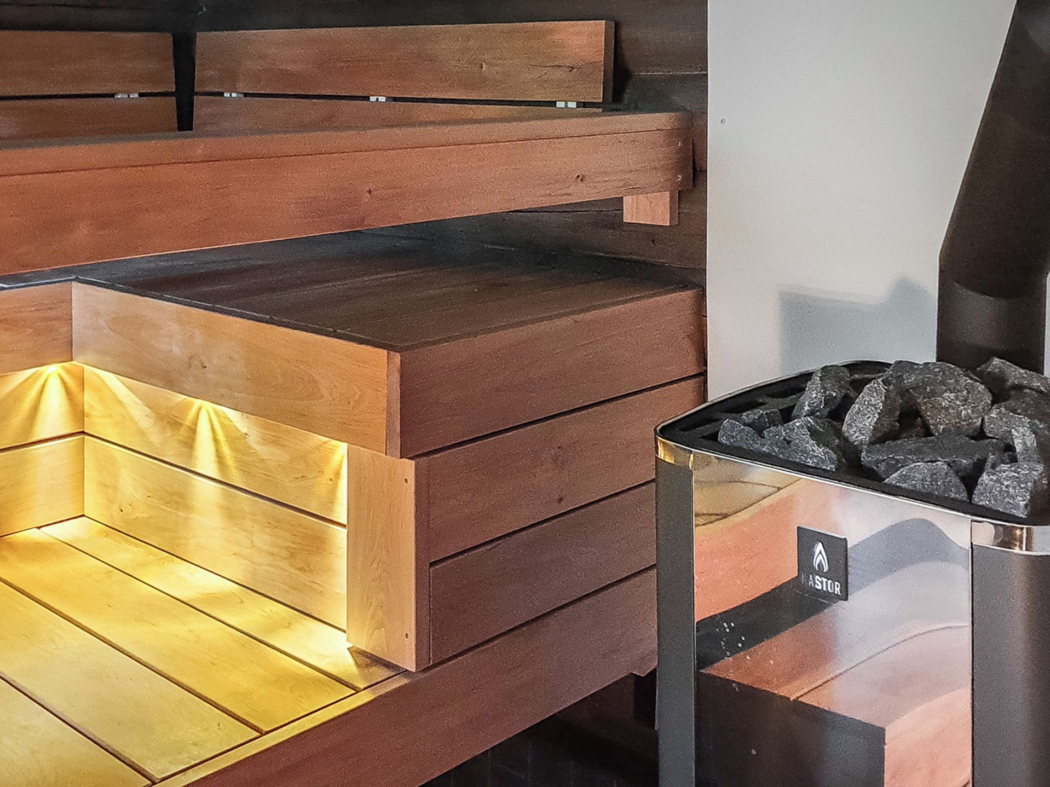 A wooden bench area with a metal grill containing charcoal.