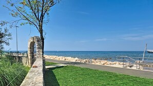A coastal pathway with a stone wall, grassy area, and a view of the sea. - Vacation home Nona by Interhome (Umag)
