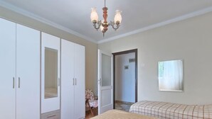 A bedroom with a large bed, a wardrobe, a mirror, and a chandelier. - Vacation home Nona by Interhome (Umag)