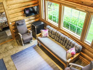 A log cabin interior with a sofa, armchair, and a television mounted on the wall. - Villa hermanni by Interhome (Pieksämäki)