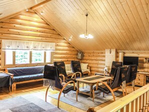 A log cabin interior with a dining area, sofa, and chairs. - Villa hermanni by Interhome (Pieksämäki)