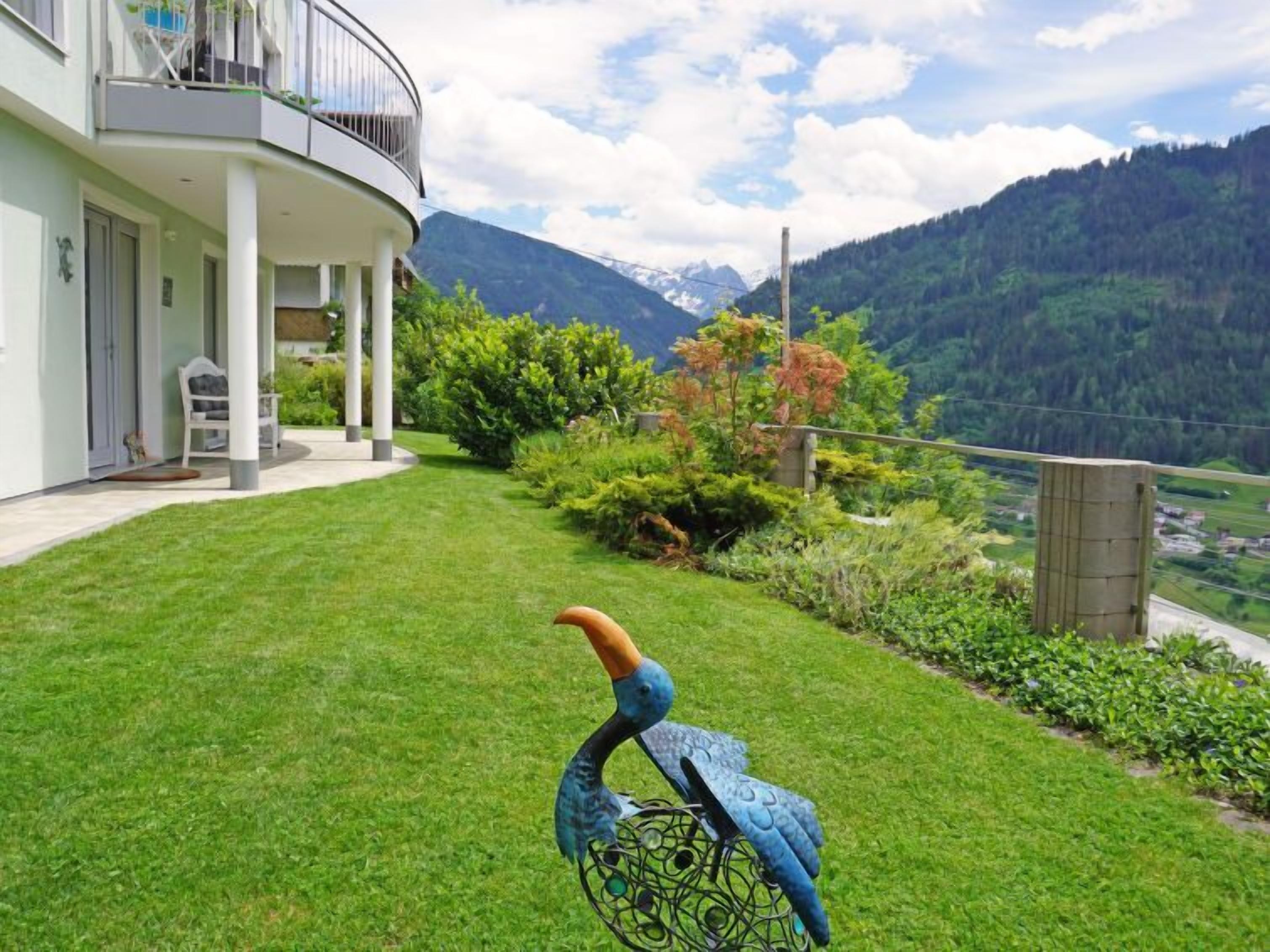 Ein modernes Haus mit Balkon mit Blick auf eine gebirgige Landschaft.