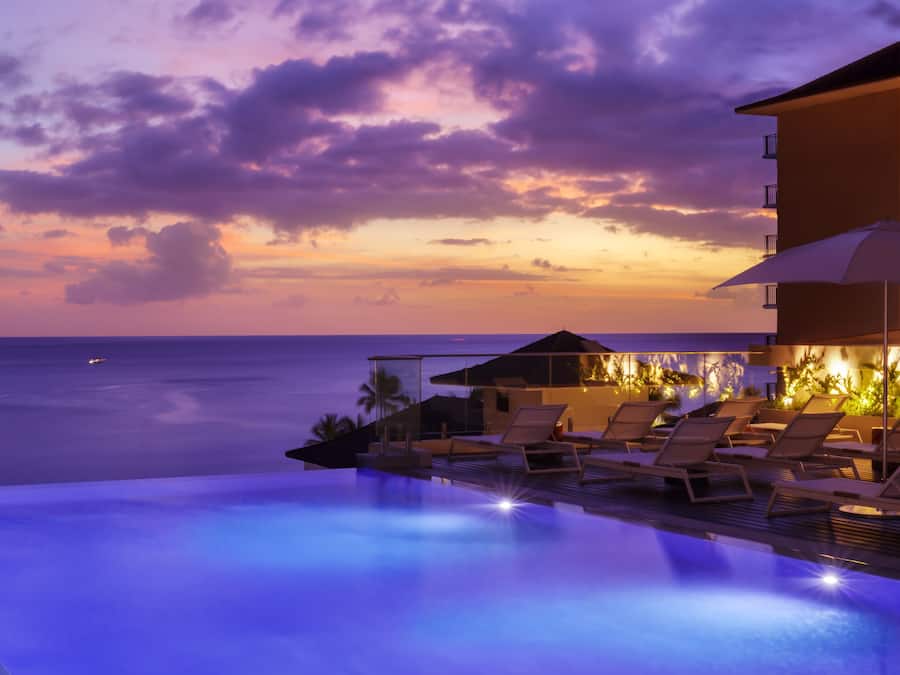 Una piscina al aire libre, camas de piscina con cargo, sombrillas