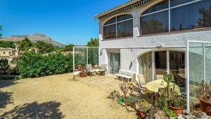A two-story house with a patio area featuring outdoor furniture and potted plants. - Vacation home Bosque by Interhome (Jávea)