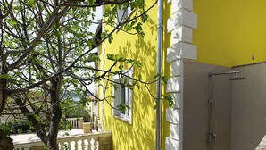 A yellow building with a white balcony and a grey door. - Apartment Anić by Interhome (Novigrad (Zadar))