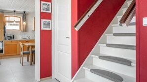 A staircase with white steps and a red wall.