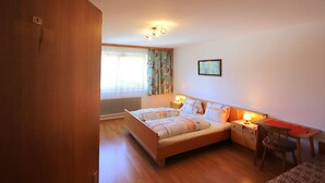 A bedroom with a bed, bedside table, chair, and a small desk with a lamp. - Jägerhof by Interhome (Schwaz)