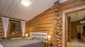 Un dormitorio rústico con cabaña, una cama, lámparas de noche y un adorno de luces.