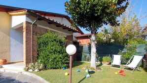 A residential backyard with a lawn, a tree, and a white spherical light fixture on a pole. - Patrizia by Interhome (Forte dei Marmi)
