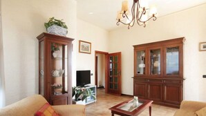 A living room with a sofa, a coffee table, a television, and wooden cabinets. - Patrizia by Interhome (Forte dei Marmi)