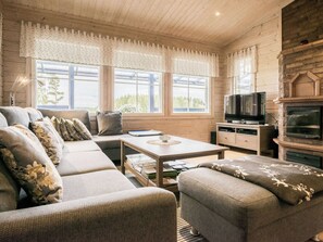 A cozy living room with a sofa, a coffee table, and a television. - Kanervarinne by Interhome (Konnevesi)