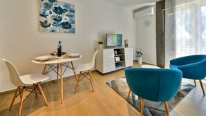 A modern living room with a dining area, featuring a TV, a painting, and a sofa. - Vacation home Matea by Interhome (Rijeka)