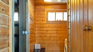 Een houten cabin interieur met een bank, een raam en een wasmachine.