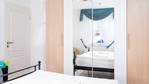 Una camera da letto con un letto, un armadio e uno specchio.