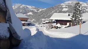 Un pueblo cubierto de nieve, con casas de madera y una montaña al fondo.