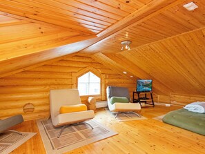 Um quarto de sótão aconchegante, com paredes de madeira e teto inclinado.