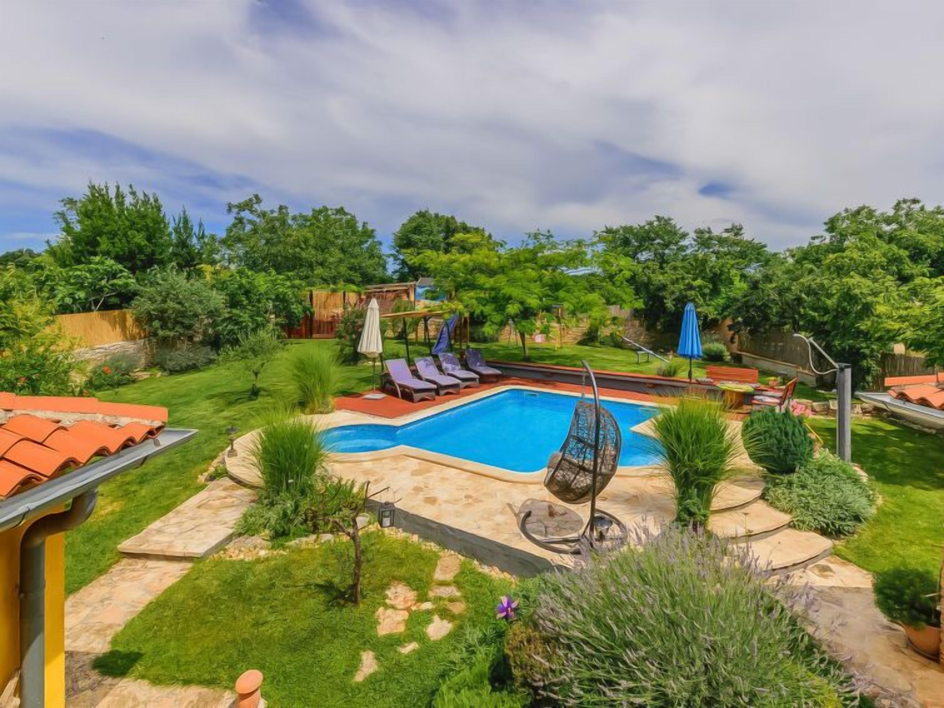 A backyard with a swimming pool, lounge chairs, and a pergola.