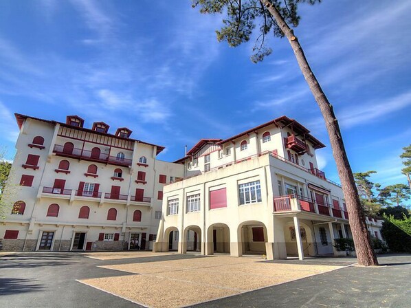 A multi-story building with a central courtyard, featuring a mix of balconies and windows.