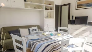 A modern, well-lit room with a bed, a dining table set for two, and a TV. - Apartment Du lac by Interhome (Hossegor)