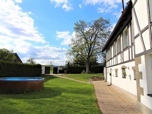 A traditional building with a large window, a pathway, and a swimming pool.