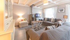 A cozy living room with a fireplace, sofa, and a television.
