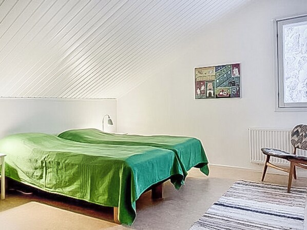 A bedroom with two beds, a radiator, a chair, and a framed picture on the wall. - Pallaksen valkkorinne by Interhome (Enontekiö)