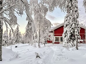 A snow-covered landscape with a red building surrounded by trees. - Pallaksen valkkorinne by Interhome (Enontekiö)