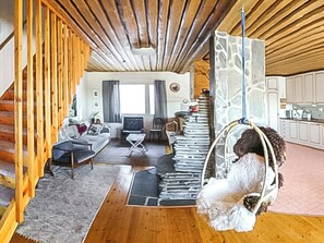 A cozy living room with a sofa, a coffee table, and a hanging chair with a dog. - Pallaksen valkkorinne by Interhome (Enontekiö)